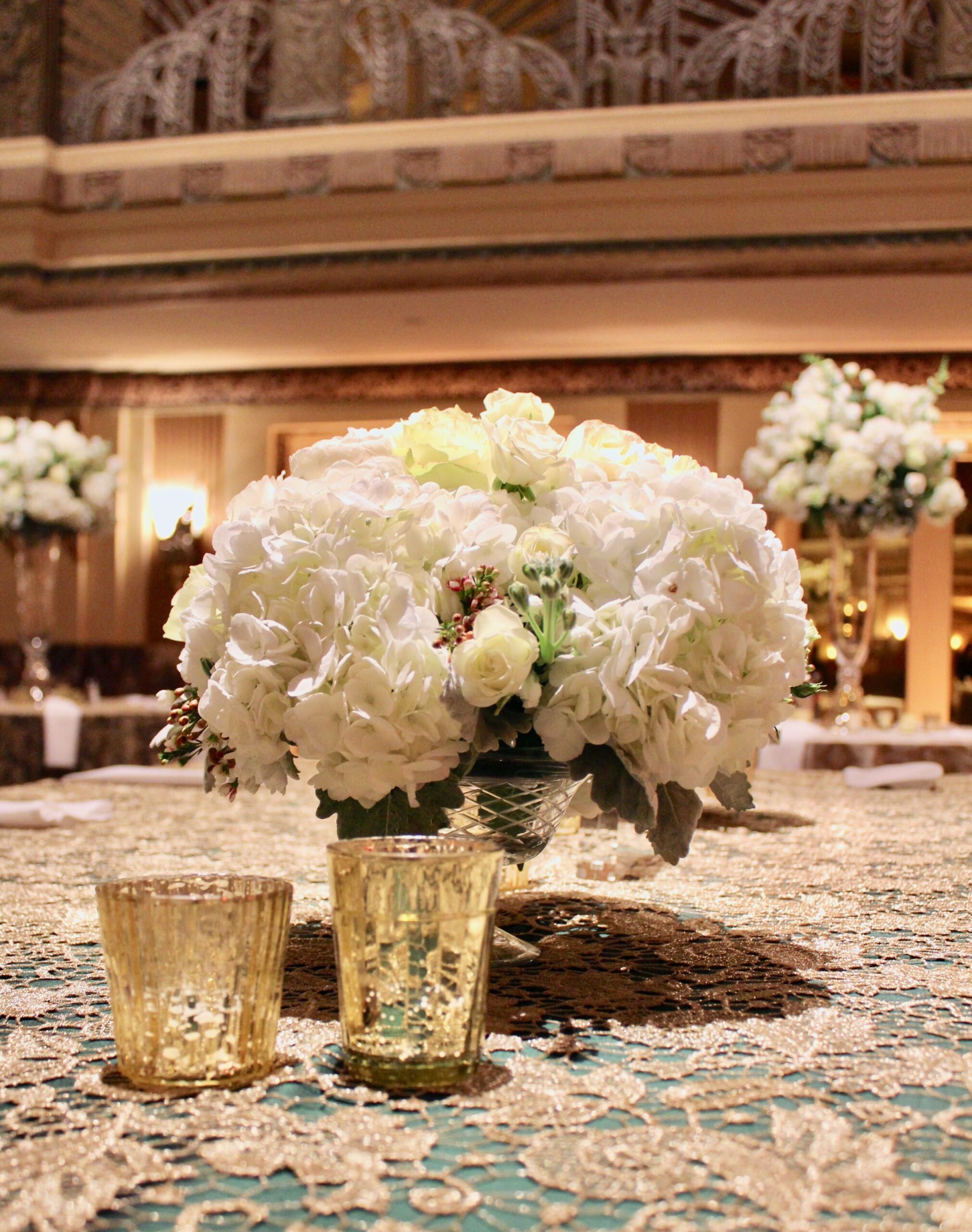 Meredith &amp; Elliot’s guests enjoyed a gorgeous reception in a room full of tall, focal arrangements full of white flowers and an assortment of greenery including eucalyptus and silvery lamb’s ear.