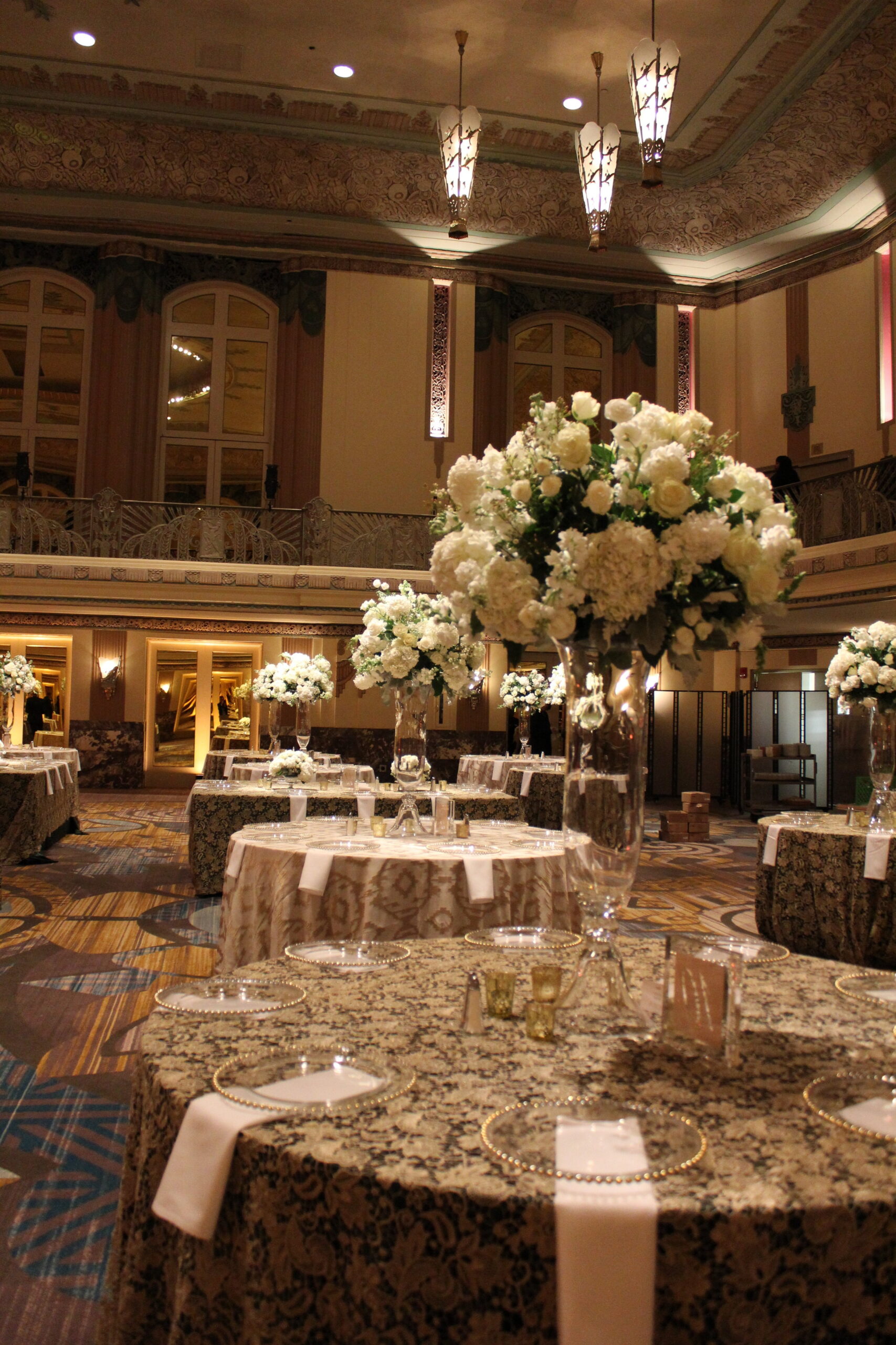 Meredith &amp; Elliot’s guests enjoyed a gorgeous reception in a room full of tall, focal arrangements full of white flowers and an assortment of greenery including eucalyptus and silvery lamb’s ear.